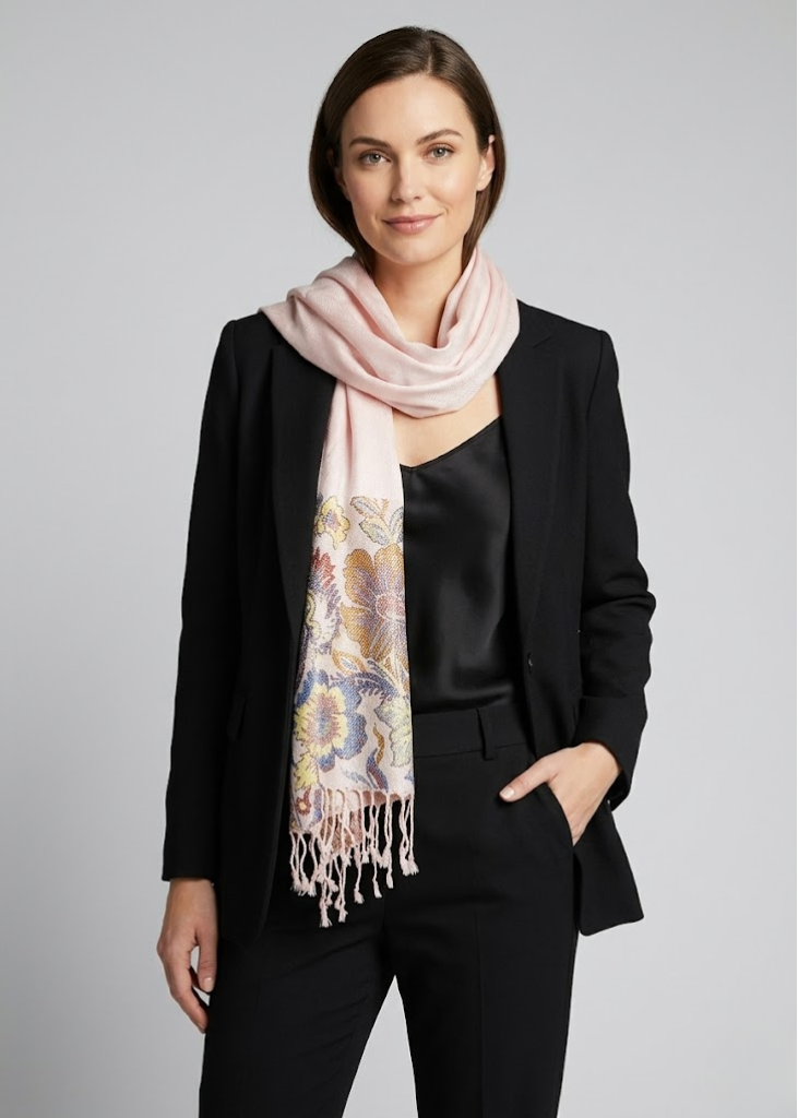 Reversible light pink pashmina wrap featuring a solid paisley print and a detailed floral border with fringe trim.
