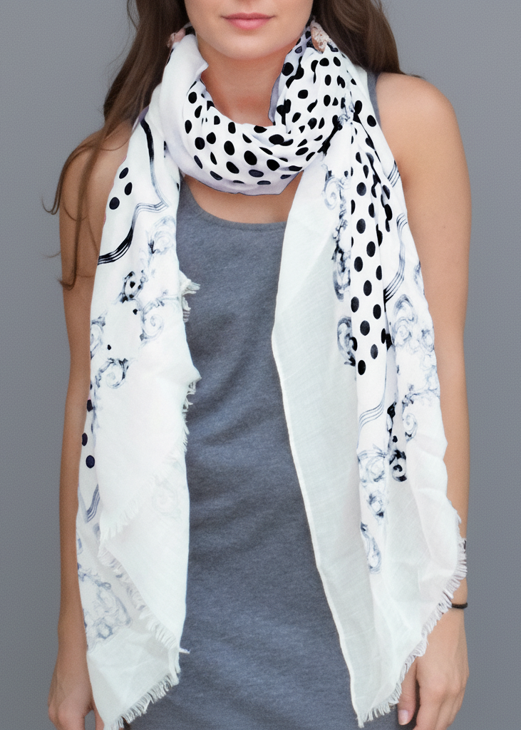 Black and white polka dot scarf featuring a chic paisley border and delicate eyelash fringe ends.