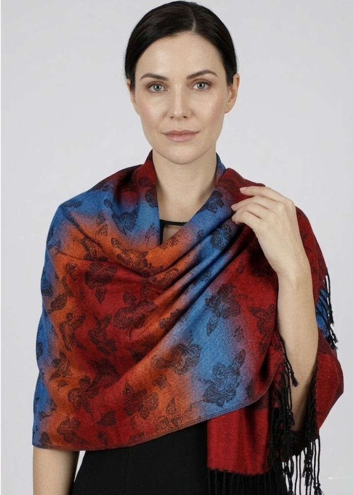 Vibrant rainbow silky tropical pashmina wrap shawl featuring a multi-colored floral pansy pattern in red and orange with fringed edges.