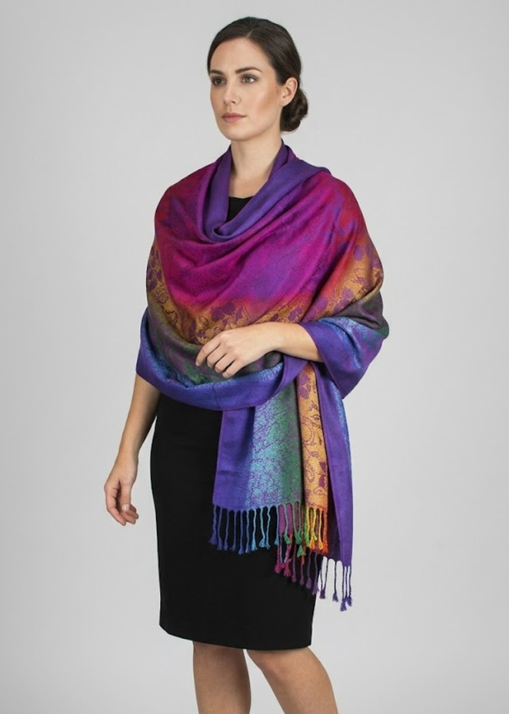 Purple pashmina shawl featuring a vibrant tropical hibiscus floral pattern with a rainbow silky finish and fringed edges.