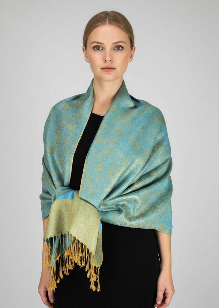 Elegant turquoise and gold reversible pashmina shawl featuring an intricate jacquard paisley pattern and hand-knotted fringe edges.