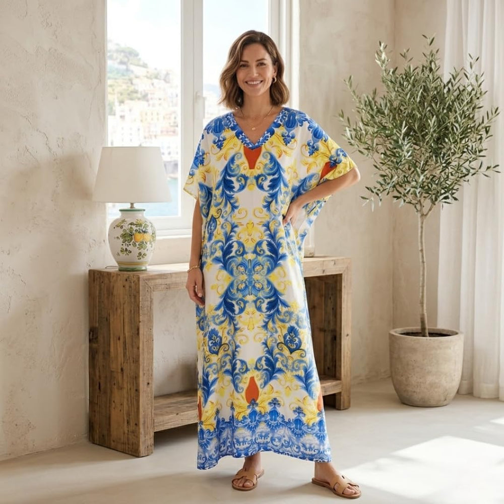 Woman wearing the Amalfi Garden floral print kaftan in yellow and blue, a lightweight maxi-length beach cover-up with a V-neck and relaxed fit.