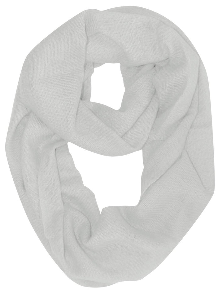 White cashmere and wool blend infinity loop scarf wrapped twice around a neck for a cozy and stylish winter look
