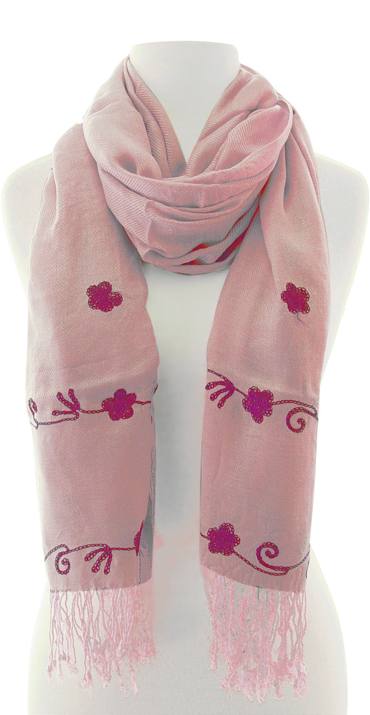 Intricate floral embroidery on a lightweight summer shawl with decorative fringe edges and a bohemian style design.